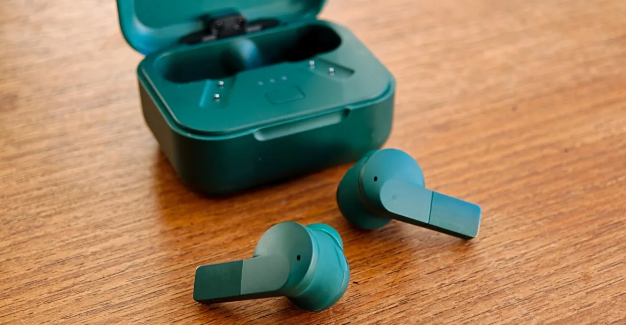 Fairbuds 2 da Fairphone sobre uma mesa, com estojo aberto mostrando os fones de ouvido e o logo da marca ao fundo