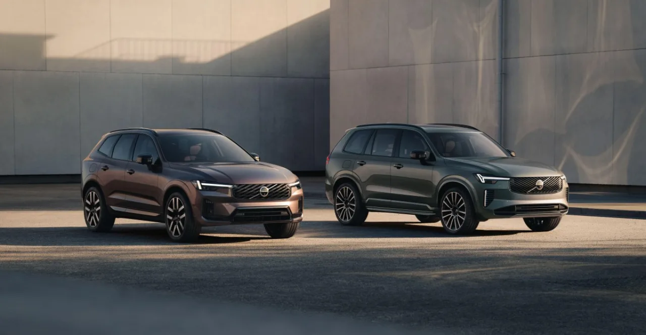 Volvo XC60 e XC90 plug‑in hybrid estacionados ao lado de um carregador, com selo verde de autonomia elétrica