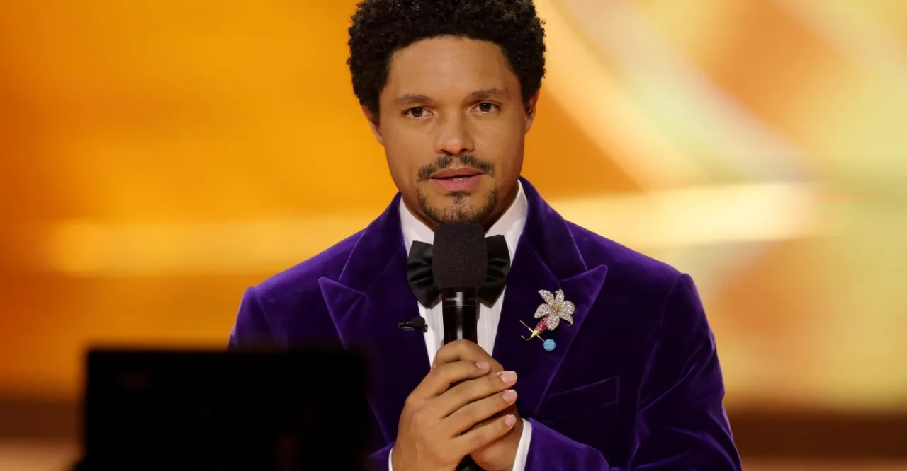 Trevor Noah faz flexões segurando o Pixel 11, com tapete de yoga e garrafa de água ao fundo