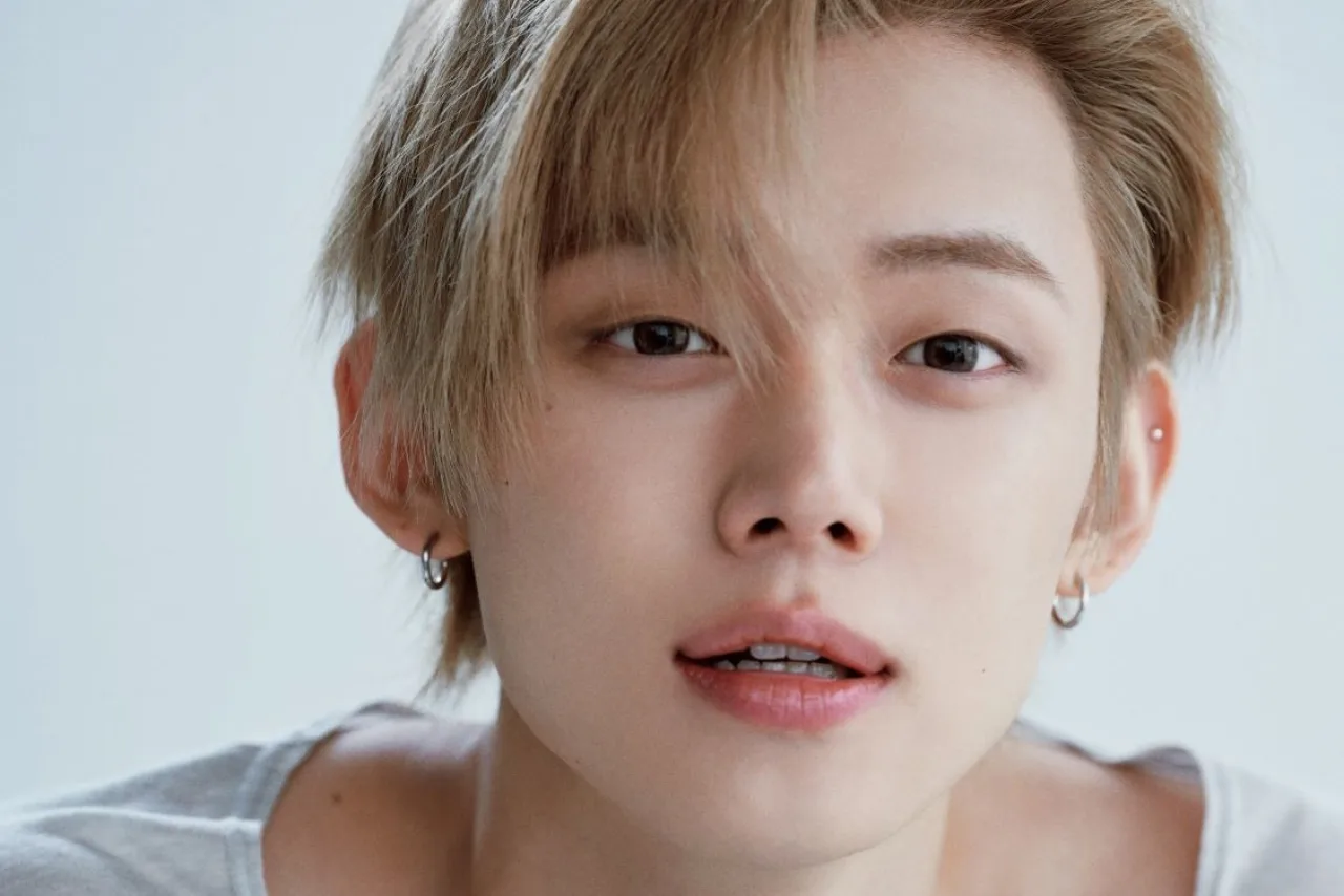 Yeonjun, do TXT, posa sorrindo ao lado de um certificado de doação e o selo da Honor Society ao fundo