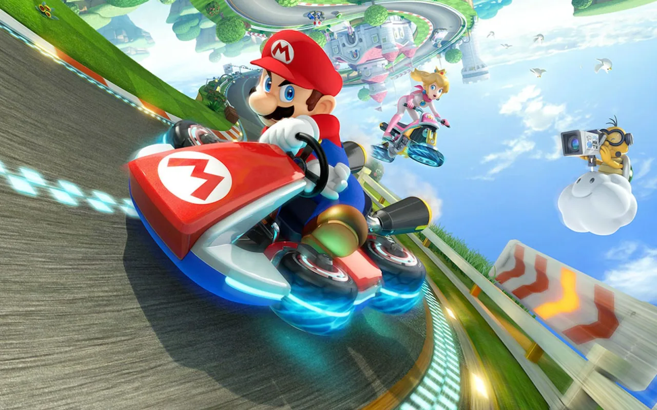 Pessoa jogando Mario Kart em um console portátil enquanto mantém uma garrafa de água e frutas frescas ao lado