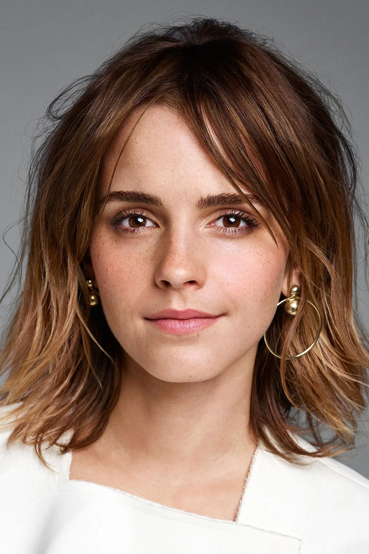 Emma Watson praticando yoga em um estúdio iluminado, vestindo leggings pretas e segurando um bloco de espuma