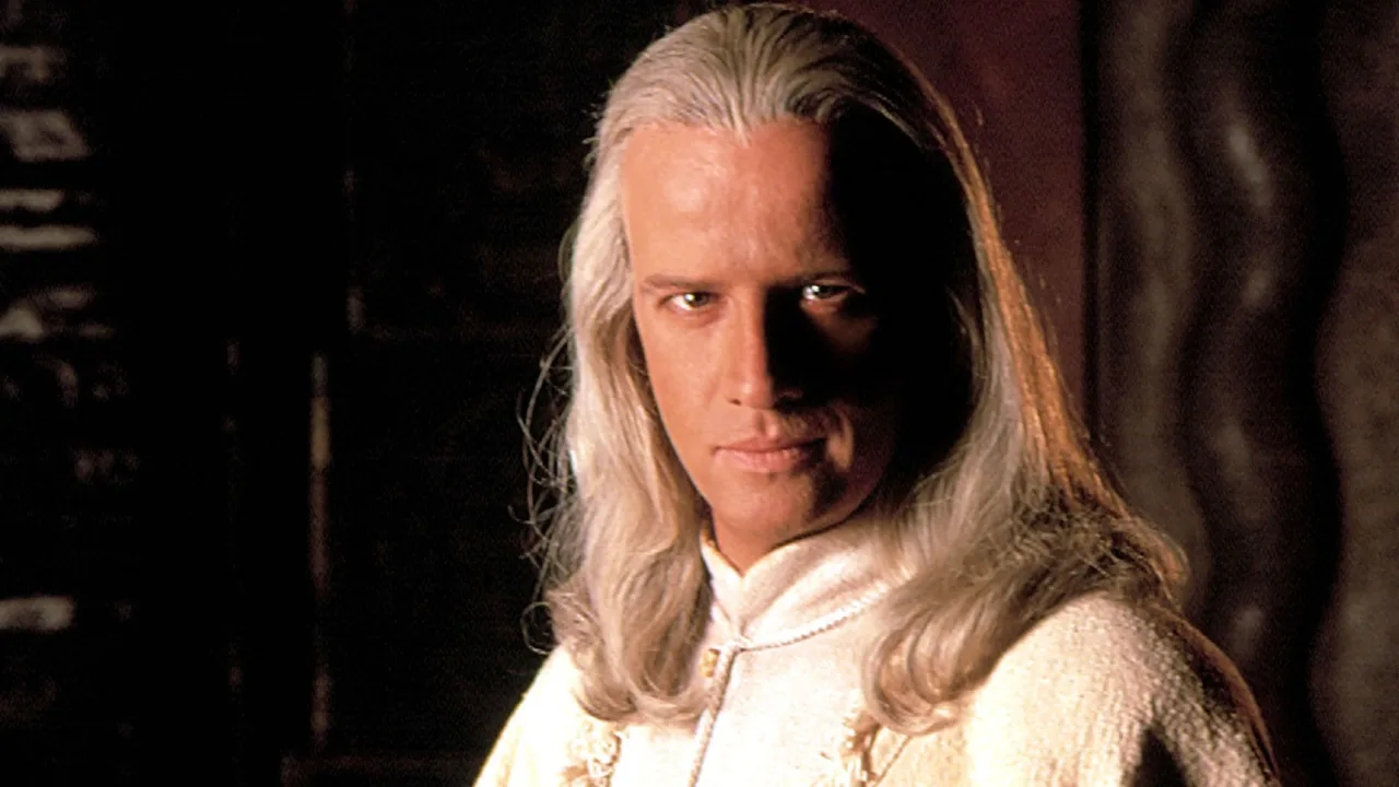 Christopher Lambert sendo atendido por socorristas, com bolsa de gelo e garrafa de água ao fundo