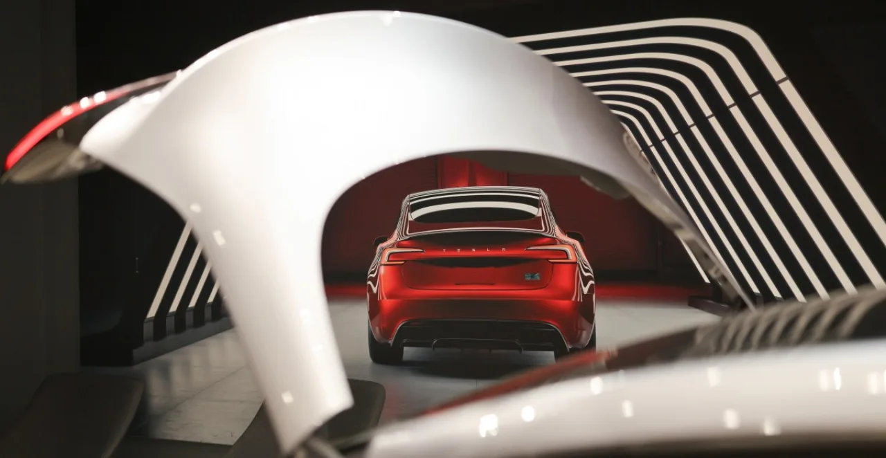 Logotipo da Tesla ao lado de um Model 3 vermelho estacionado, com gráfico de queda de entregas ao fundo