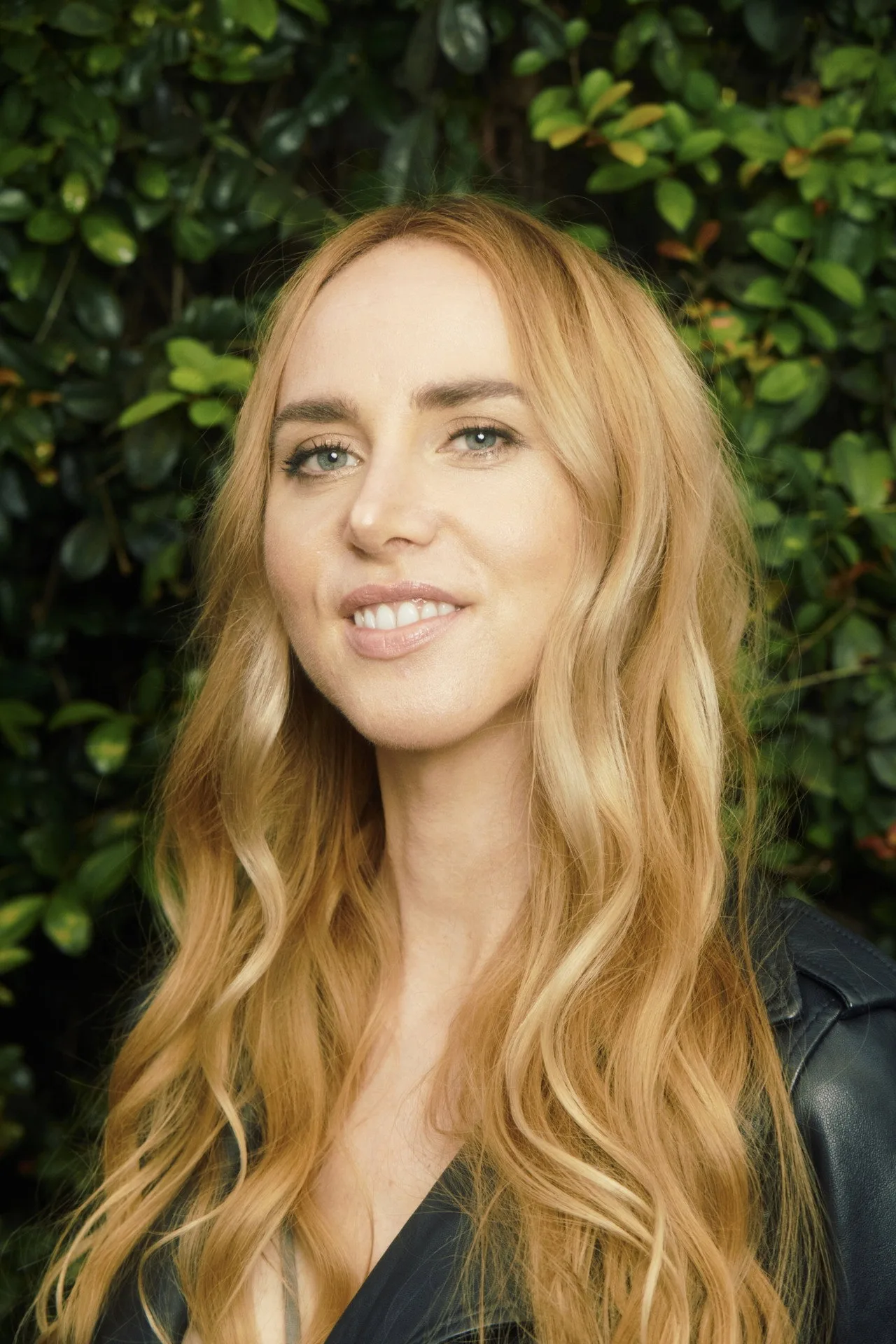 Sydney Sweeney faz alongamento ao ar livre com tapete verde, segurando uma garrafa de água detox