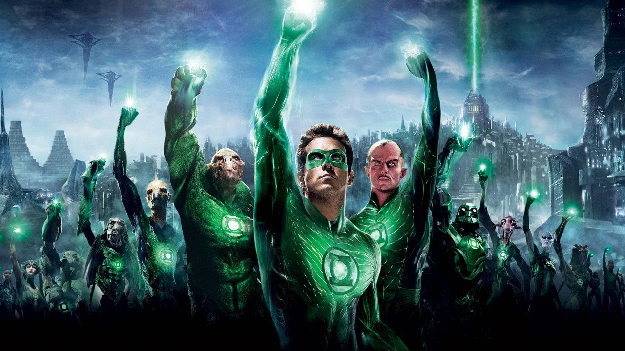 Ryan Reynolds levanta halteres verdes ao lado de um traje de Green Lantern, com garrafa d'água e toalha ao fundo
