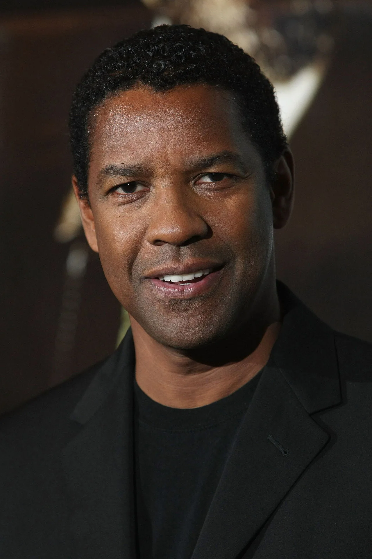 Denzel Washington em cena de suspense, segurando uma lanterna em ambiente escuro com atmosfera de mistério policial
