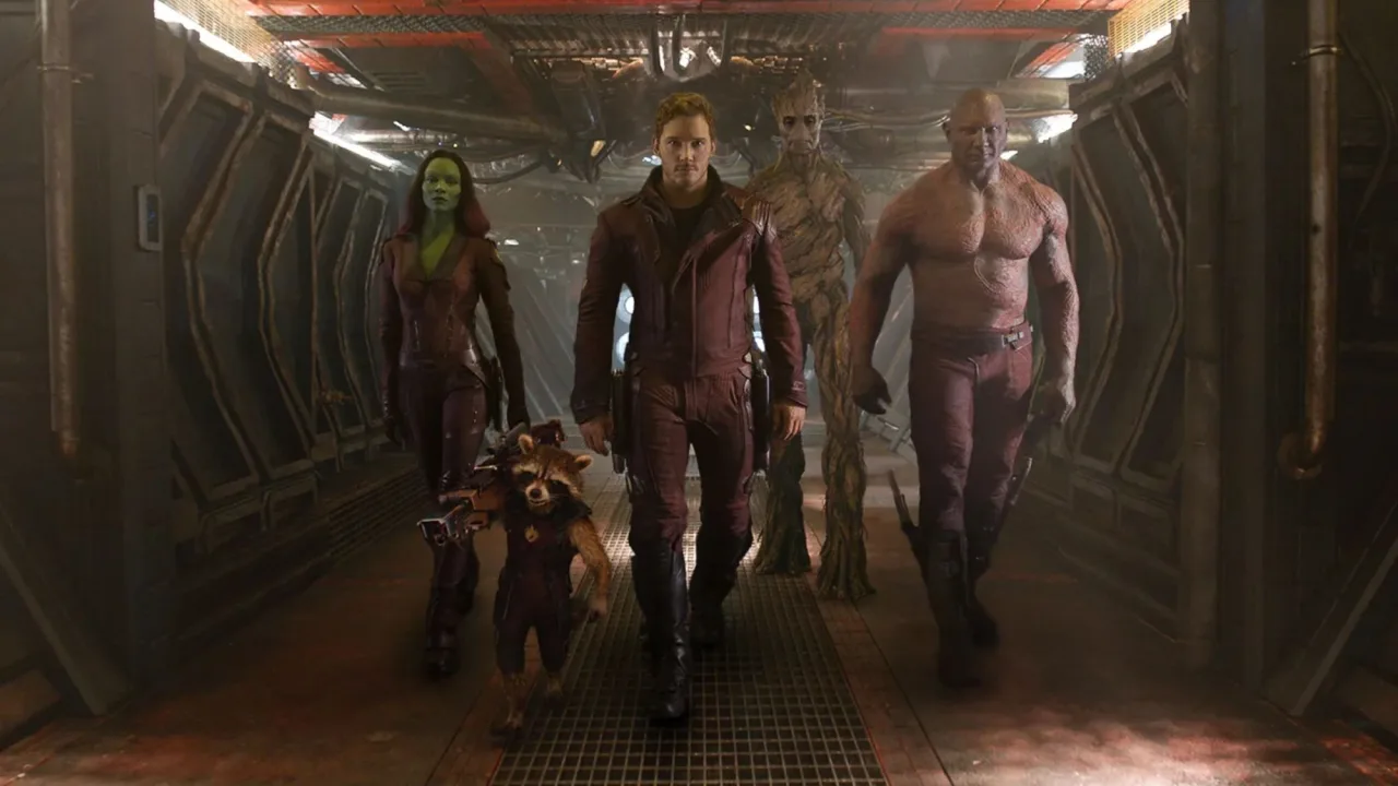 Rocket segurando um haltere enquanto Groot levanta uma barra e Star‑Lord corre numa esteira futurista