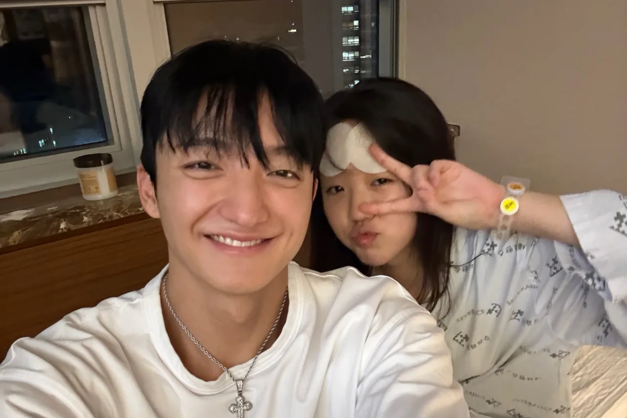 Casal sorrindo, segurando smartphones com mensagens de Instagram e anéis de casamento ao fundo