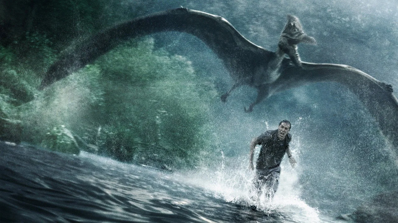 Um corredor em pista ao ar livre, vestindo camiseta verde com logo de dinossauro e segurando garrafa de água