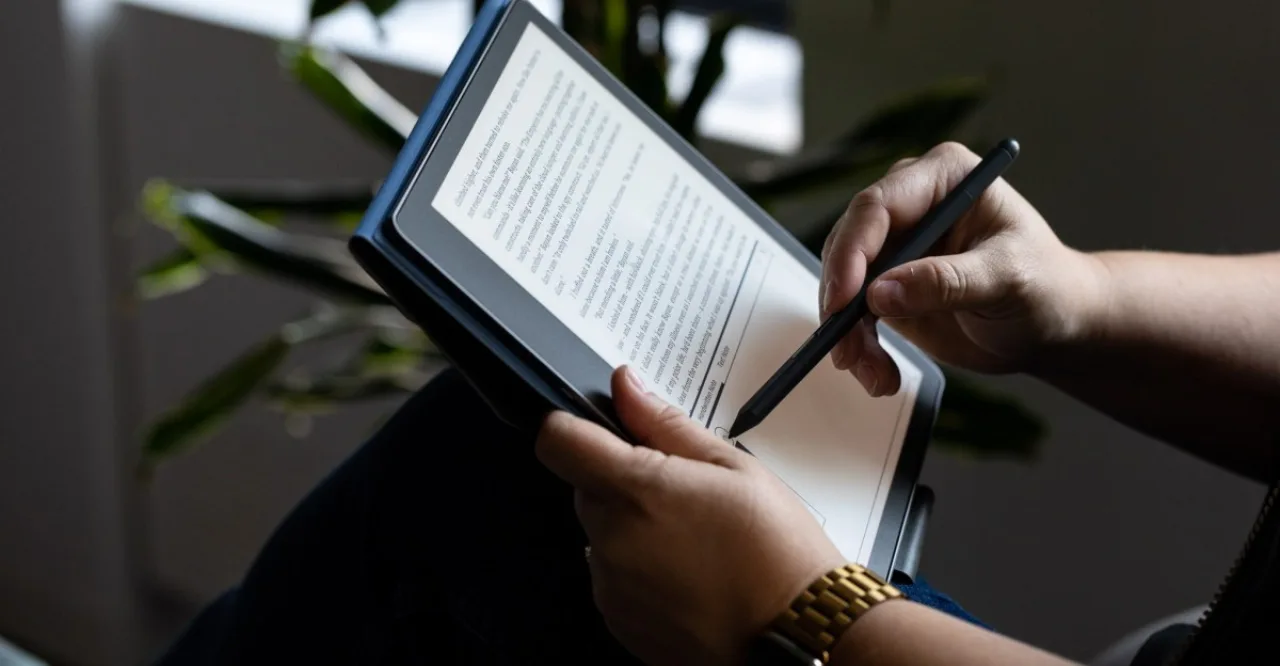 Jovem em roupa de academia segurando Kindle Scribe recondicionado enquanto faz alongamento