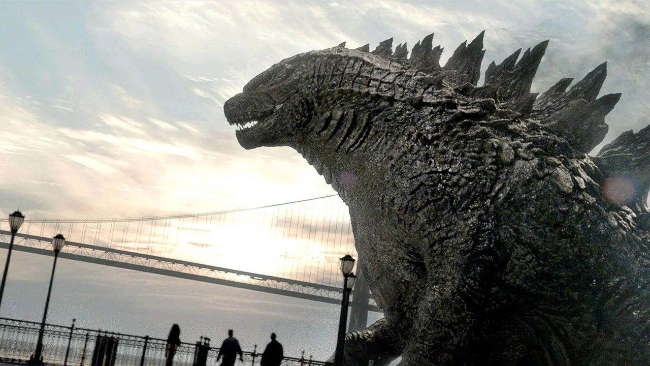 Homem suando em esteira, ao fundo tela de cinema mostrando Godzilla emergindo de escombros
