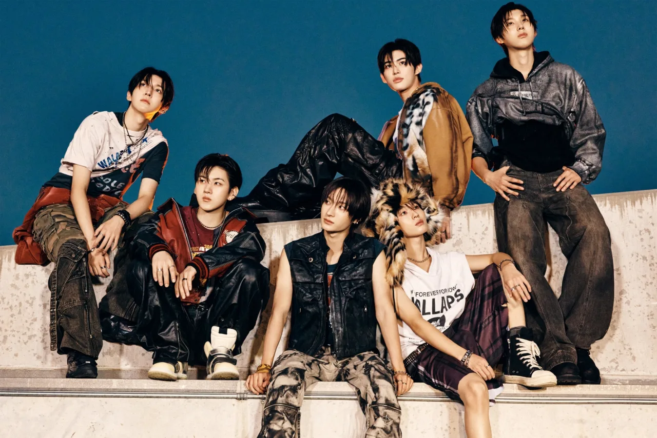 Membros do KickFlip posam em trajes neon ao lado do mini‑álbum ‘KICK OFF THE WALL Pt. 1’ e do logo da JYP