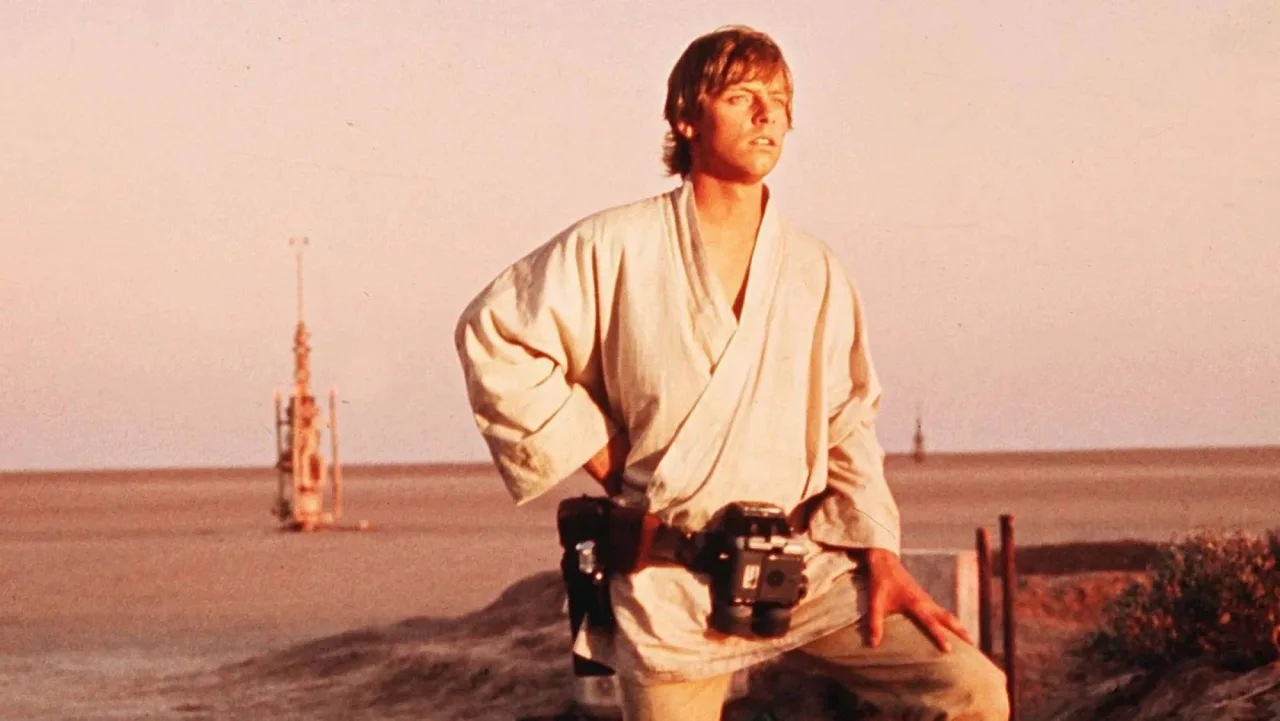 Homem musculoso segurando a figura de Luke Skywalker enquanto faz supino com barra
