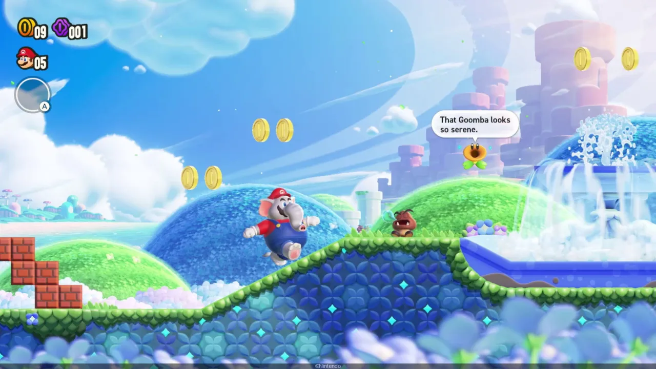 Elephant Mario em miniatura, com tromba e bigode, posado sobre base preta ao lado da caixa da First 4 Figures