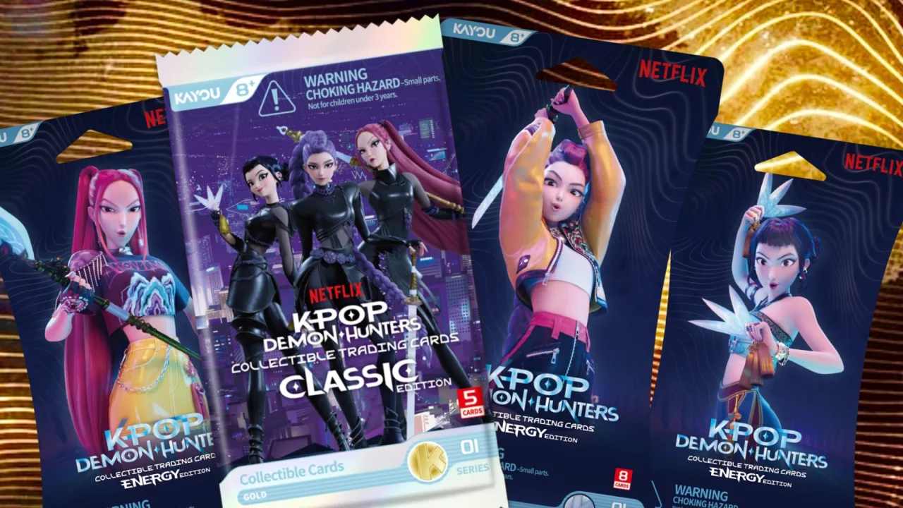 Jovem fã segurando cards brilhantes da coleção KPop Demon Hunters ao lado de um álbum organizador temático