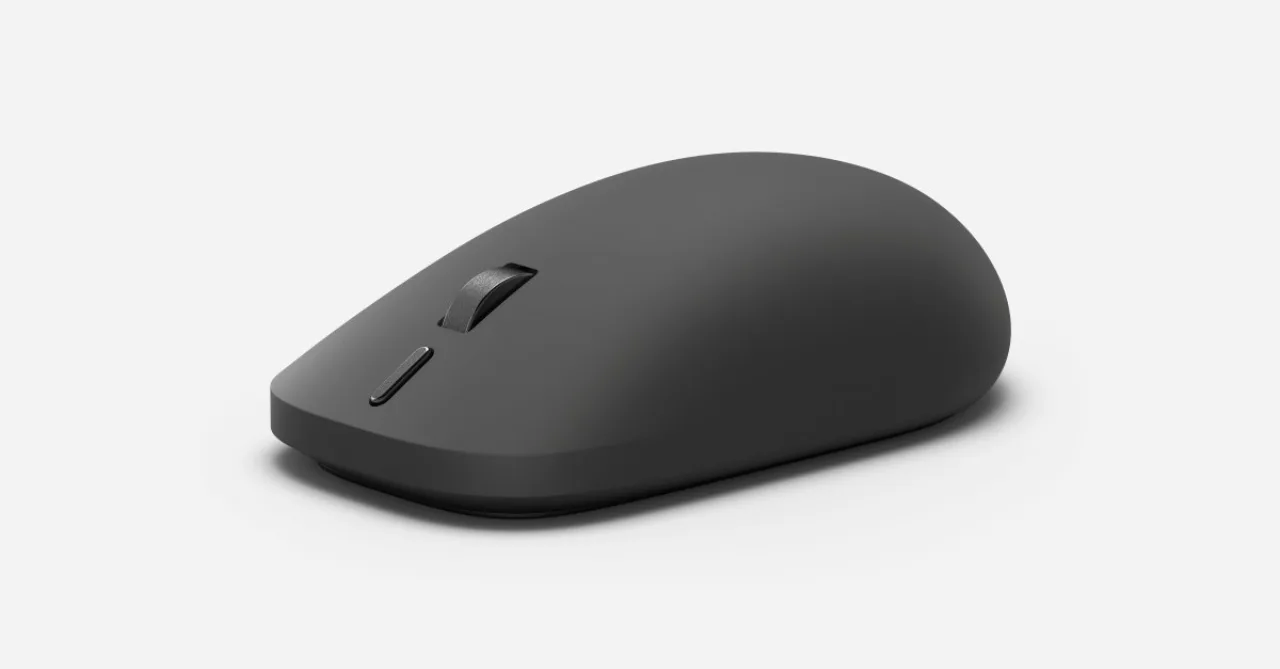Surface Mouse 2 da Microsoft com acabamento prateado, botão Copilot destacado e efeito de vibração visível