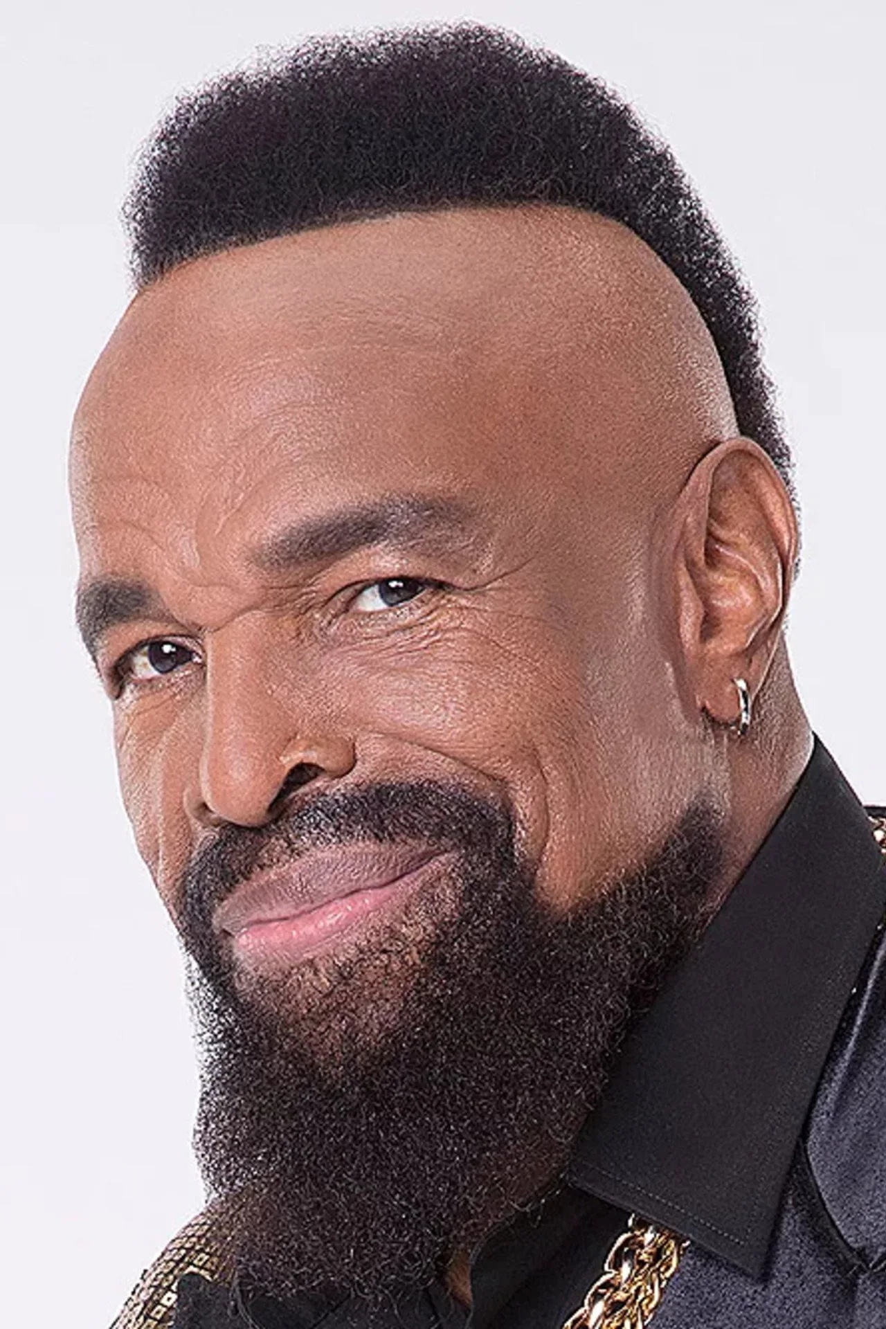 Homem musculoso vestindo o robe azul‑claro e shorts de Mr. T, fazendo flexões com halteres ao lado de um cronômetro