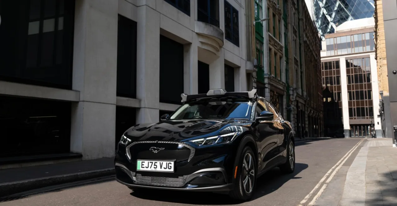 Corredor de roupa esportiva com fones, ao lado de um robotaxi branco nas ruas movimentadas de Londres