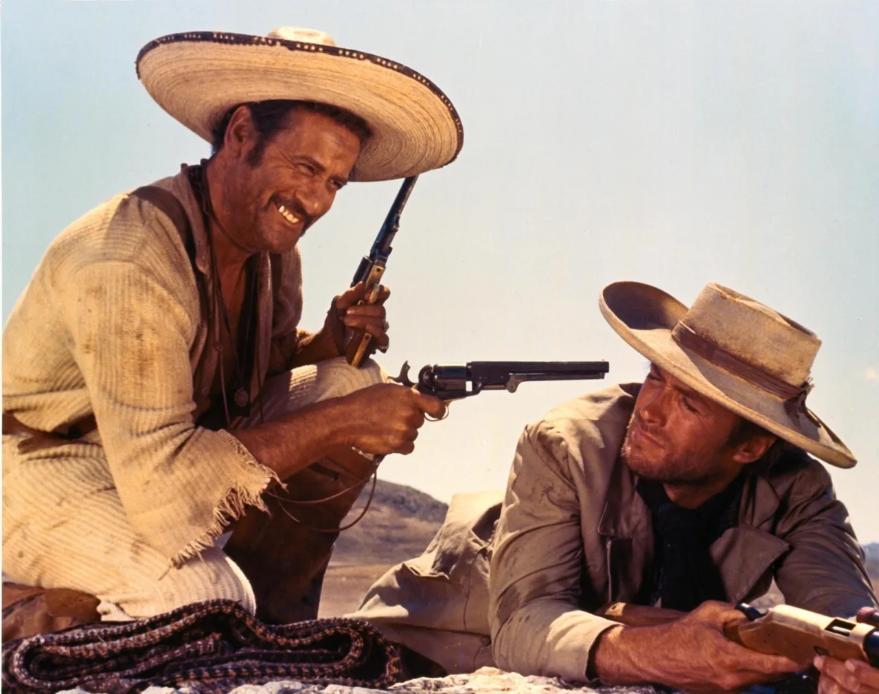 Poster de The Good, the Bad and the Ugly com Clint Eastwood, Eli Wallach e Lee Van Cleef em duelo no deserto