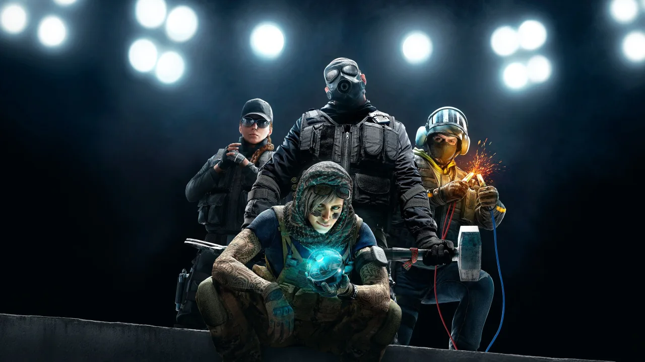Funcionários da Ubisoft Barcelona segurando cartazes de protesto, com laptops e garrafas de água na mesa