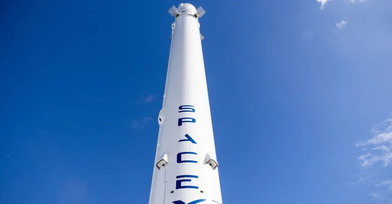 Gráfico financeiro em alta sobreposto à silhueta de um foguete da SpaceX sendo lançado ao espaço sideral