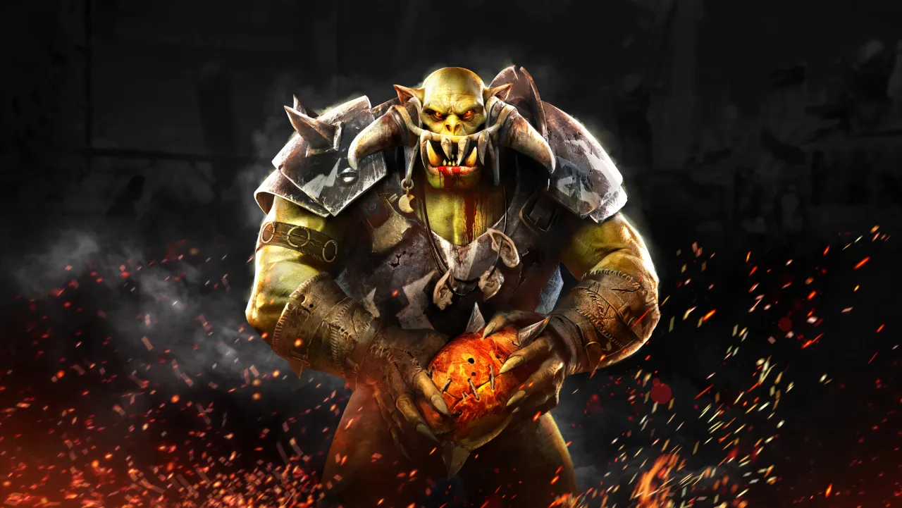 Jogador segurando halteres, vestindo camiseta da Slitherine, ao fundo um tabuleiro de Blood Bowl com miniaturas