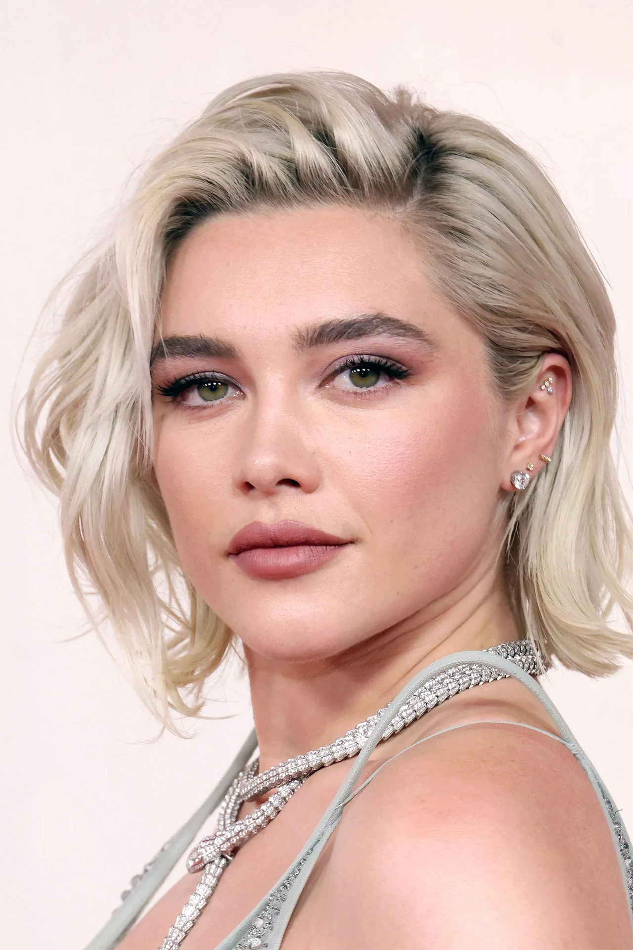Florence Pugh como Yelena Belova ao lado de Spider‑Man, ambos em ação, com luzes neon e painéis de tecnologia ao fundo