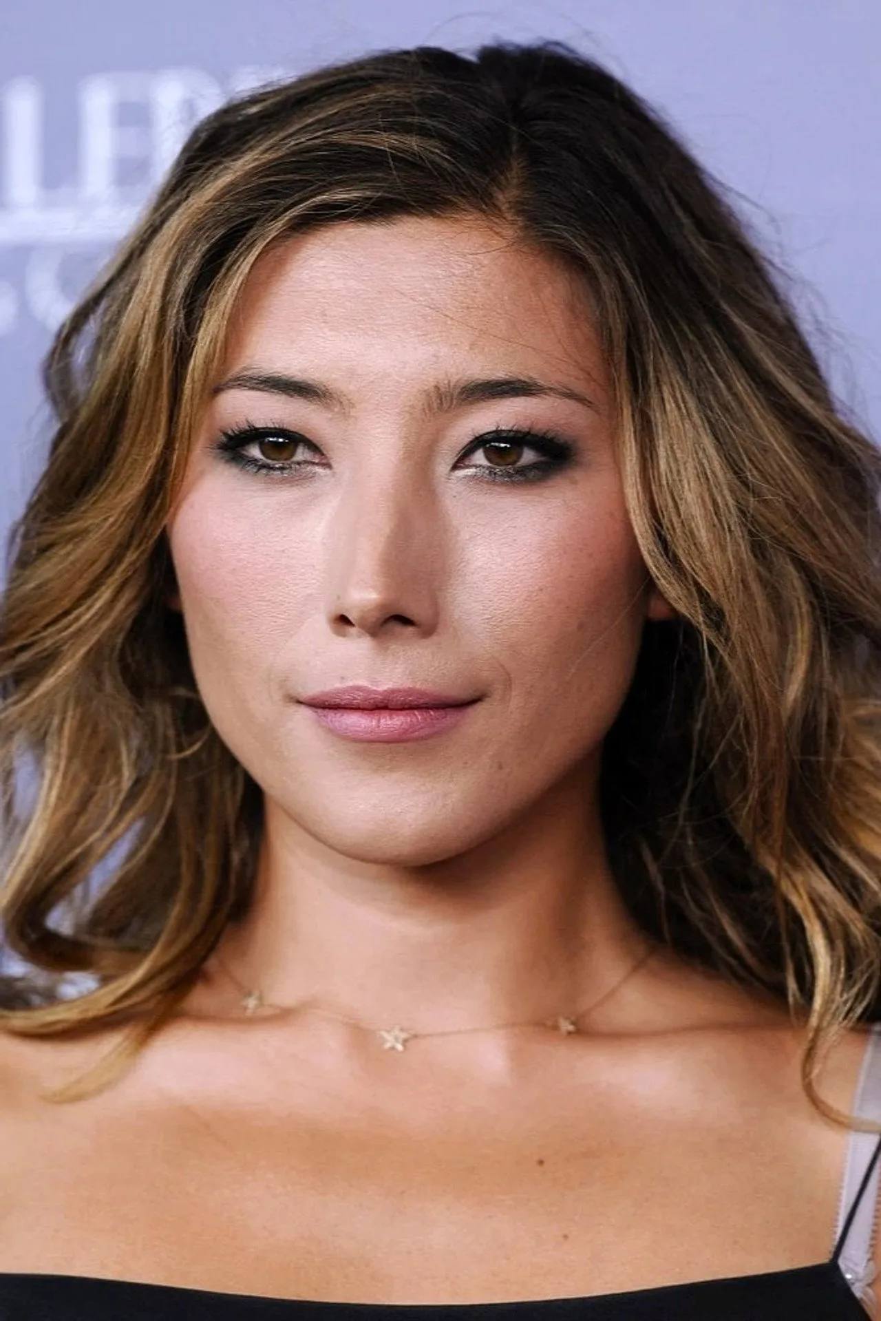 Sam Neill fazendo supino, Dichen Lachman em prancha lateral, Yvonne Strahovski segurando halteres; academia iluminada ao fundo