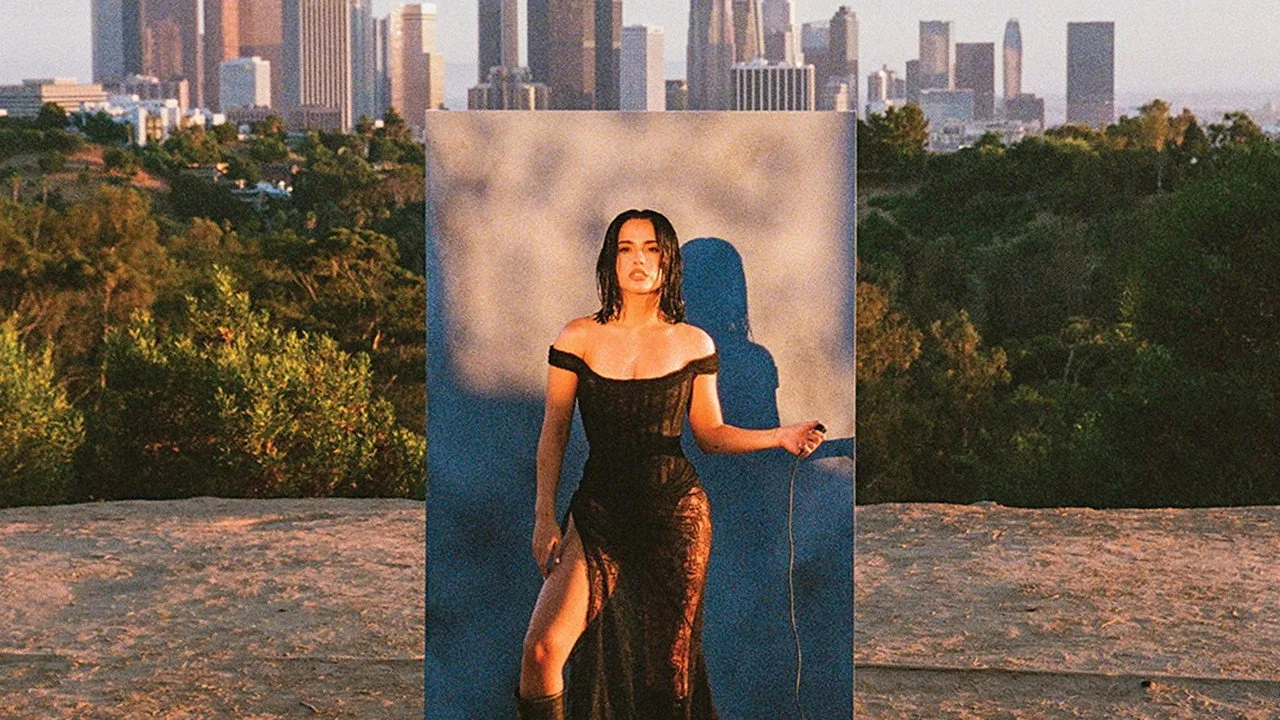 Becky G vestindo roupa de treino vermelha, segurando halteres e um copo de água ao lado de um poster dos Power Rangers