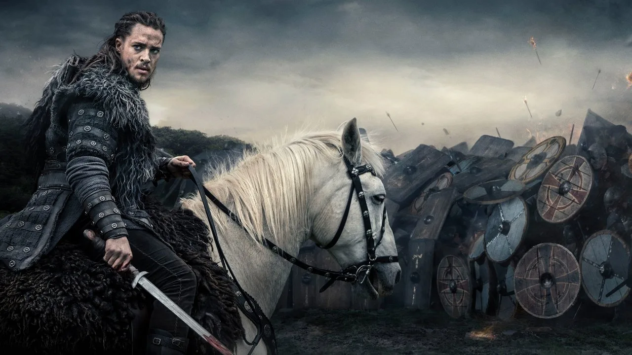Homem em armadura viking levanta kettlebell de ferro ao lado de um copo de água e um livro de história