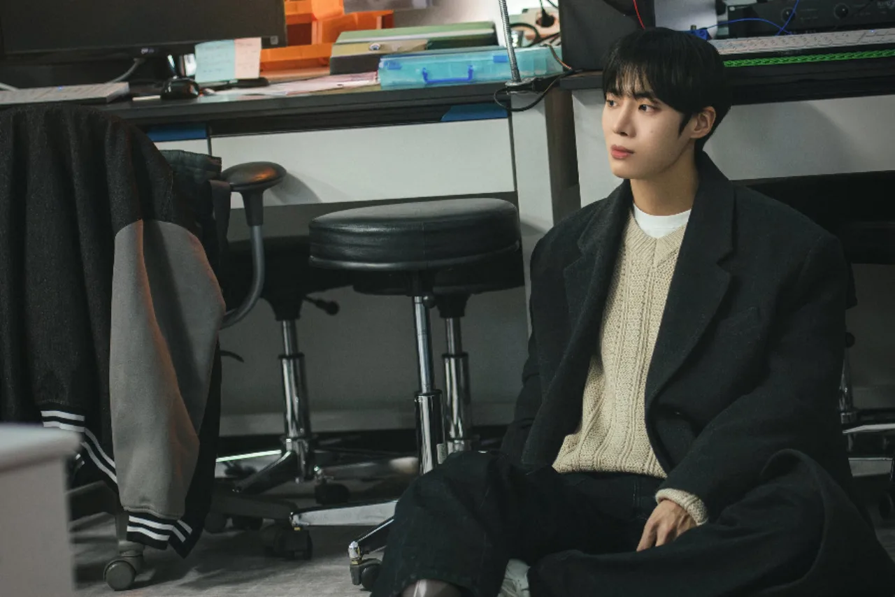Choo Young Woo como Park Min Jae, sentado no chão de um laboratório, cercado por equipamentos científicos