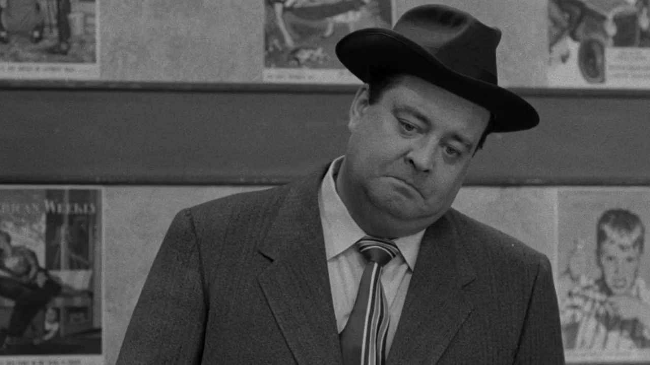 Couch vintage dos anos 50 com controle remoto, pipoca e halteres ao lado, sugerindo maratona de sitcoms