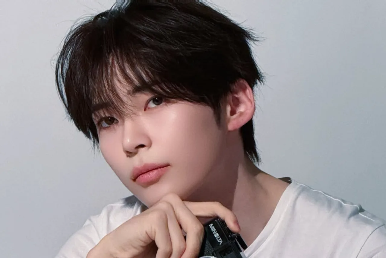 Sung Han Bin posando com a capa do EP “DEAD:ALIVE”, microfone na mão e o logotipo da ZEROBASEONE ao fundo