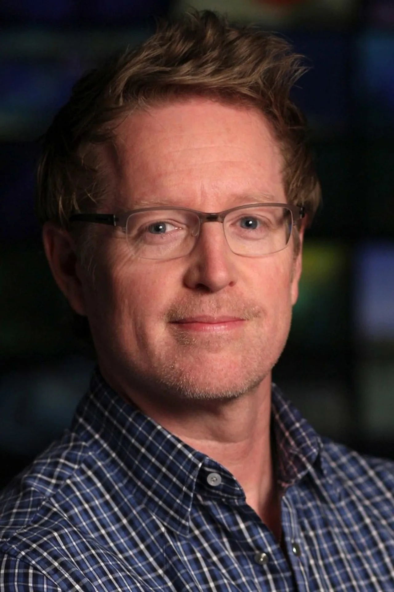 Andrew Stanton segurando um boneco do Woody ao lado de um laptop aberto com roteiro de Toy Story 6