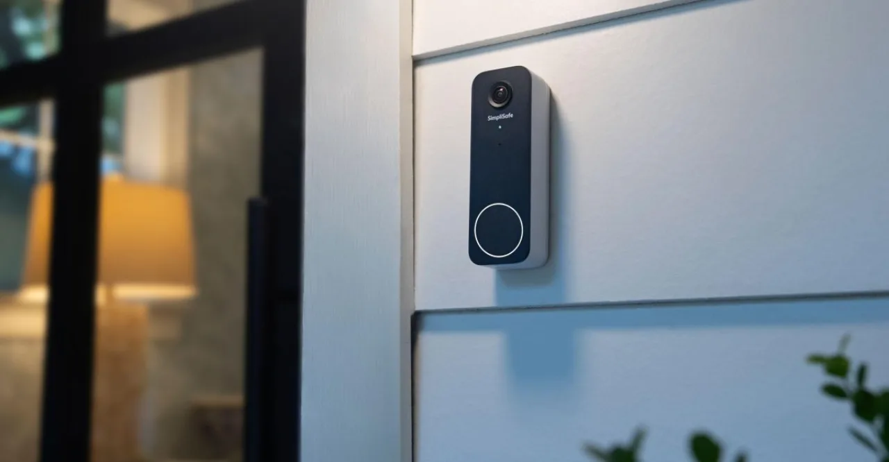 Campainha inteligente SimpliSafe Video Doorbell Series 2 instalada na porta, com logo da marca e tela de smartphone exibindo vídeo ao vivo