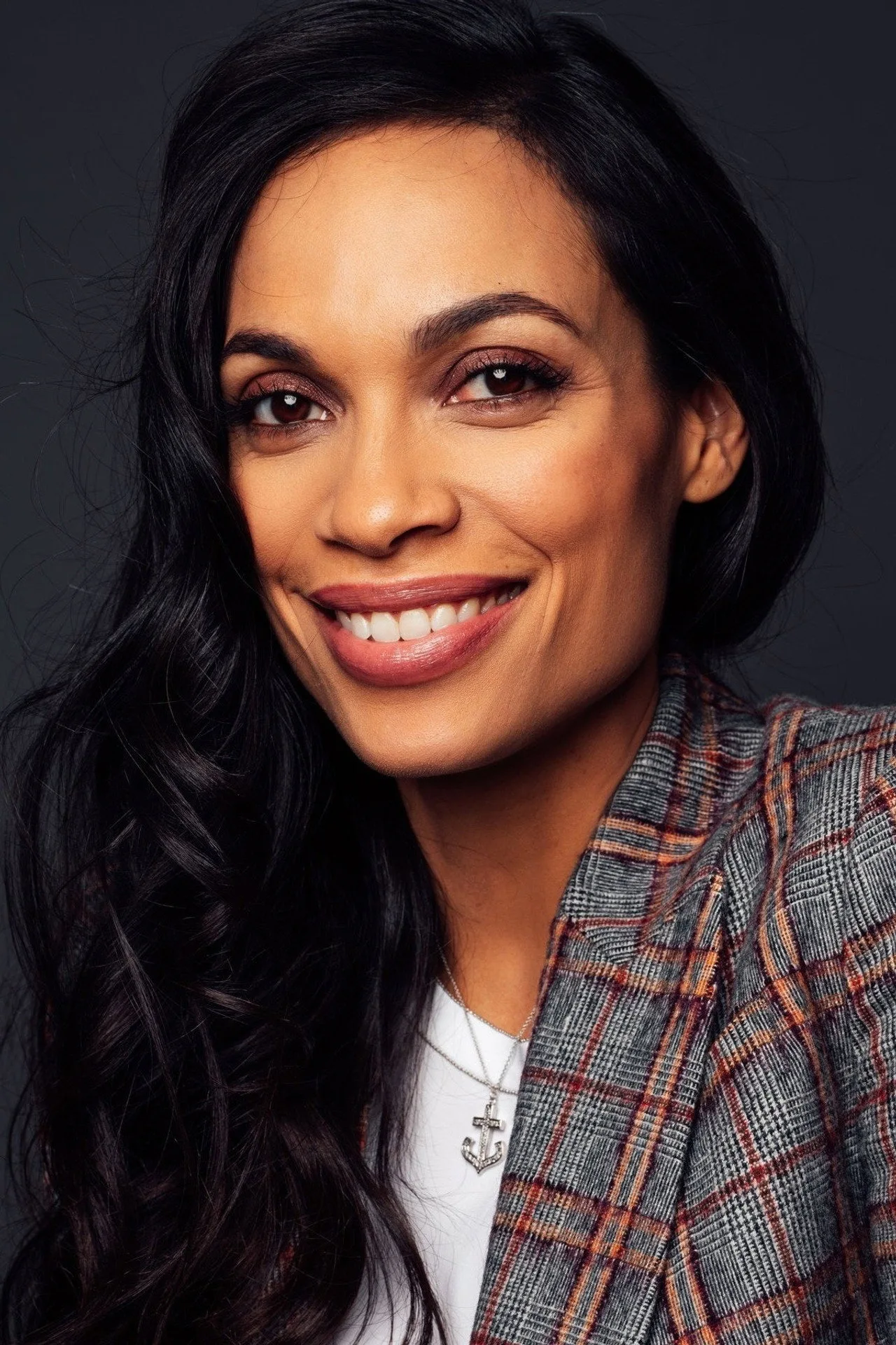 Claire Temple em roupa de treino, segurando halteres ao lado de uma caixa de suplementos
