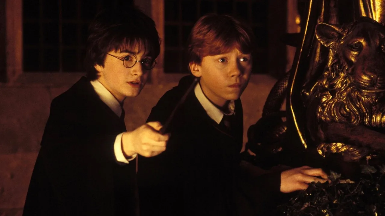 Jovem em roupa de academia levanta halteres ao lado de varinha, capa de Hogwarts e garrafa de água com escudo dourado