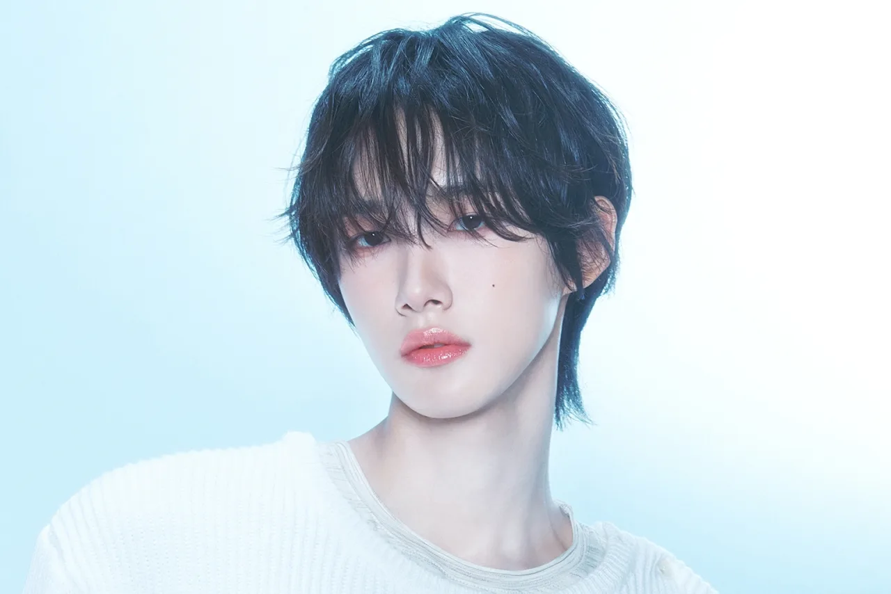 Lee YoonSung em pé, segurando um microfone, com o logotipo da MODHAUS ao fundo