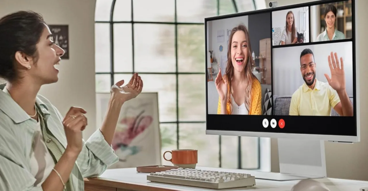 Pessoa em roupa esportiva usando o monitor 4K Samsung M80F para seguir treino de HIIT, com halteres e garrafa d'água ao lado