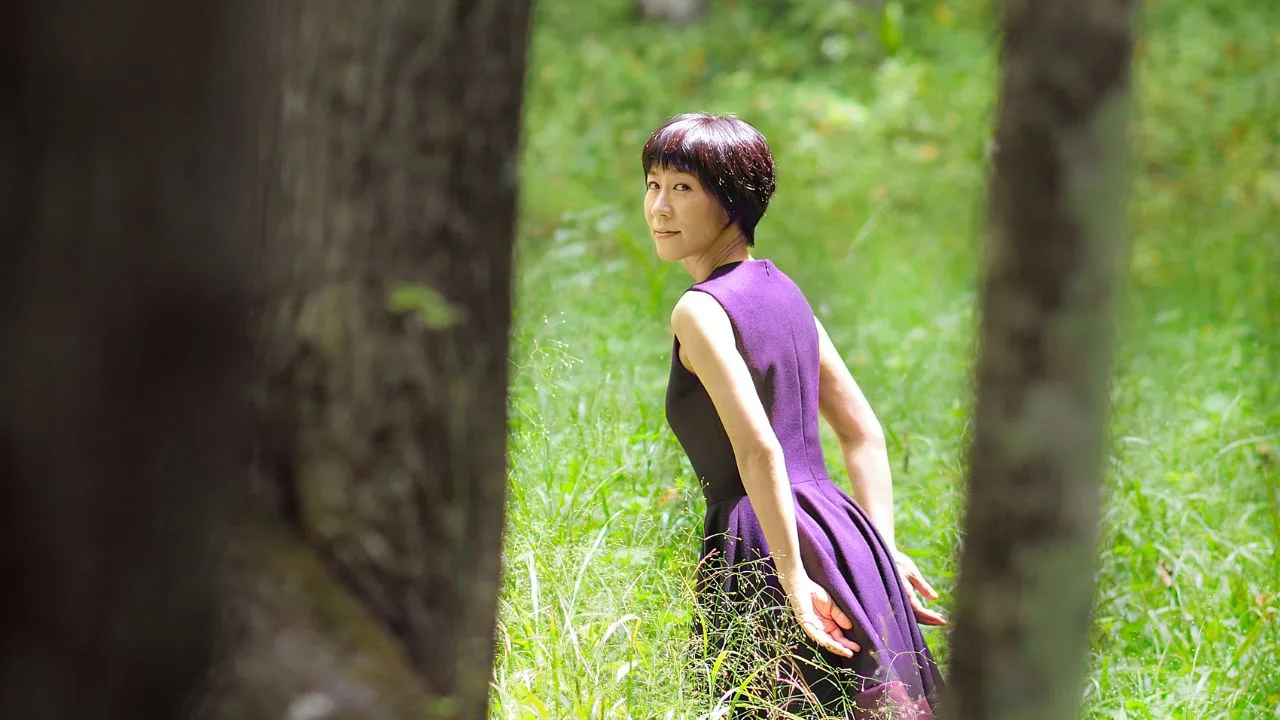 Yoko Kanno no palco da Lucca Comics & Games 2026, ao lado de um banner do evento e microfone