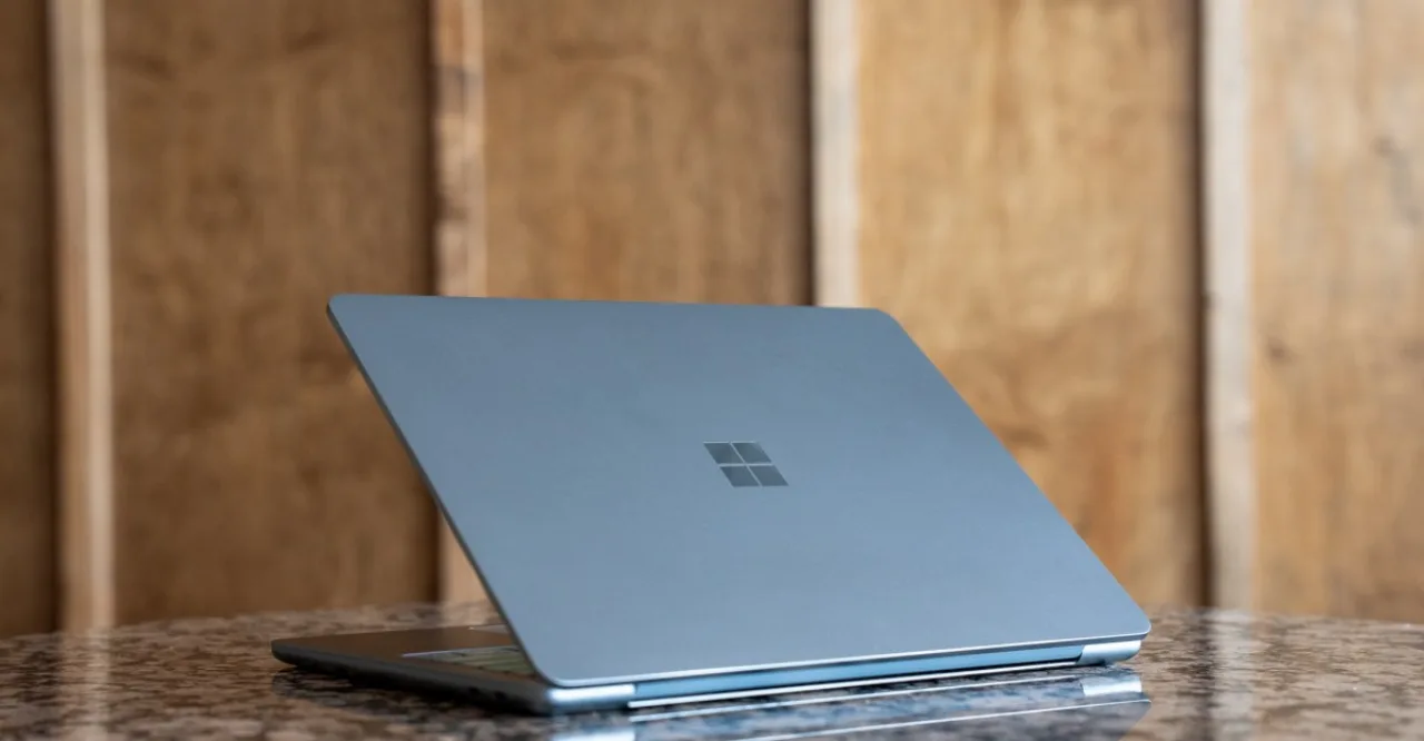 Pessoa em roupa esportiva faz alongamento usando Surface Pro 12" sobre um tapete de yoga