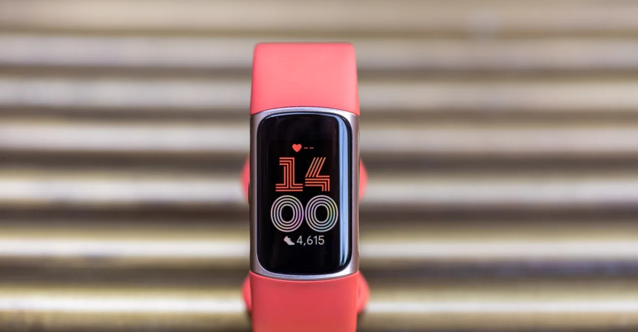 Fitbit Charge 6 e Ace LTE lado a lado sobre uma bancada, com caixa aberta mostrando as pulseiras e o logo da Amazon