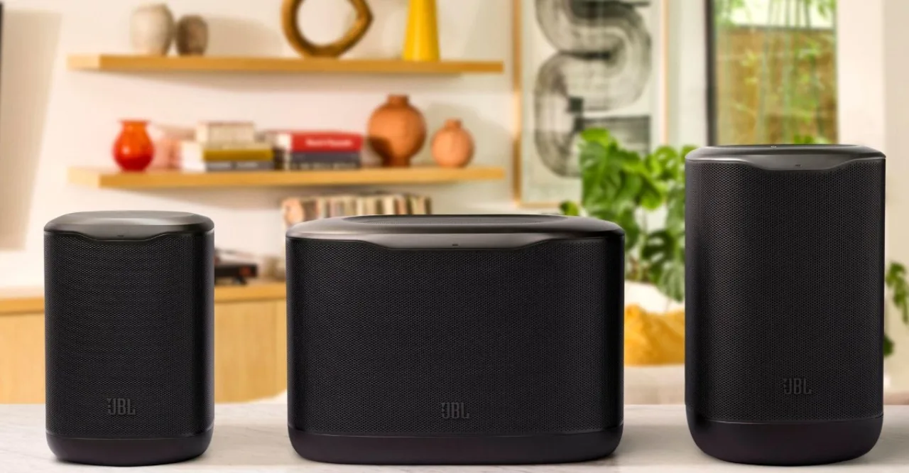 Jovem praticando yoga na sala, com caixa JBL Cove ao lado e controle Sonos na mesa, ambiente iluminado