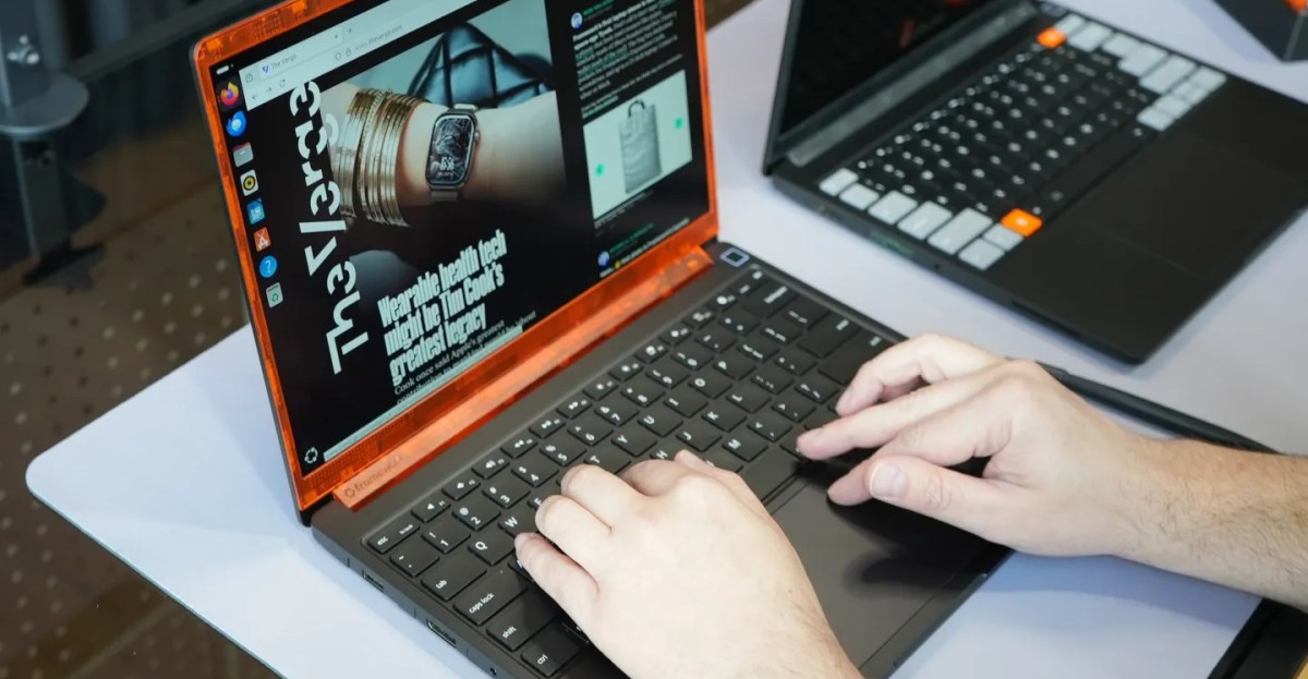 Pessoa sentada em banco de academia, usando o Framework Laptop 13 Pro enquanto segura uma garrafa de água