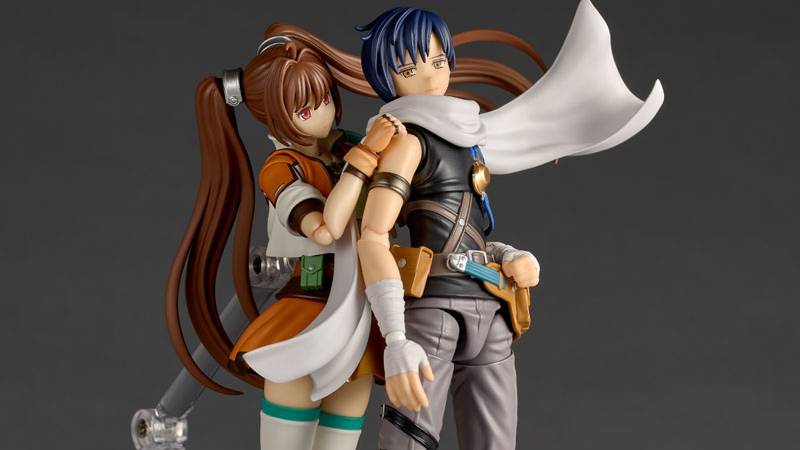 Figura Revoltech de Joshua Astray ao lado de halteres e um tapete de yoga, com garrafa d'água ao fundo