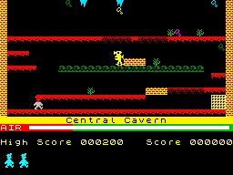Jovem em roupa esportiva joga Manic Miner no console enquanto faz agachamentos ao lado de garrafa d'água