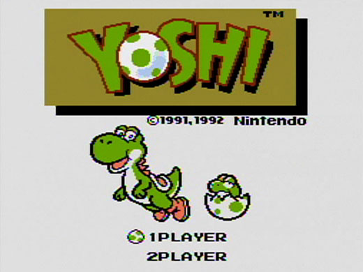 Pessoa jogando Nintendo Switch com fones de ouvido ao lado de um Yoshi de pelúcia e um copo de suco natural