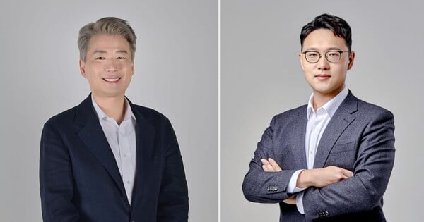 Yongsoo Kim e Gyu‑nam Kim, em ternos, posam ao lado do logo da Naver Webtoon em um ambiente corporativo